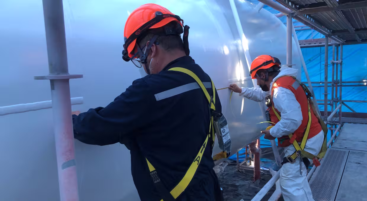 Medición de Estanques de Almacenamiento 2 Personas haciendo una medicion de un estanque de almacenamiento