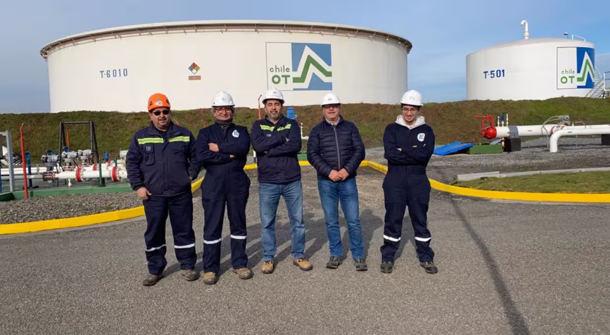 Equipo de BZ Consulting Parte del equipo de Bz Consulting en frente de unos tanques de almacenamiento